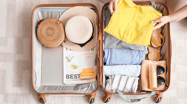 woman neatly organize suitcase and packing light for roadtrip